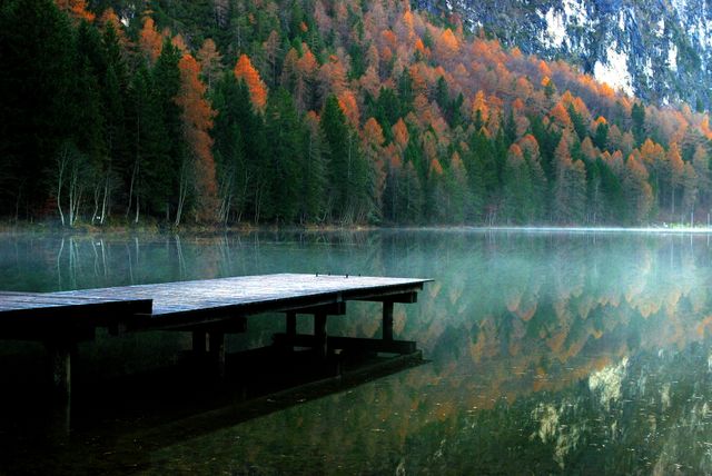 Serene Autumn Lake with Wooden Pier and Reflected Trees - Download Free Stock Photos Pikwizard.com