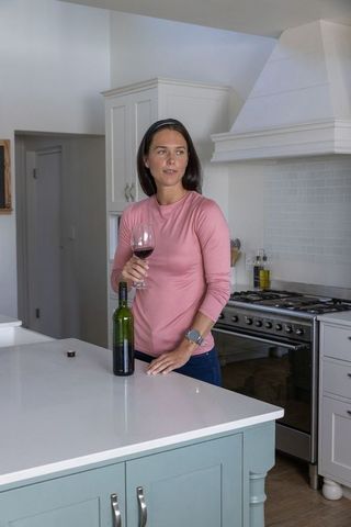 Woman Holding Wine Glass in Modern Minimalist Home Kitchen