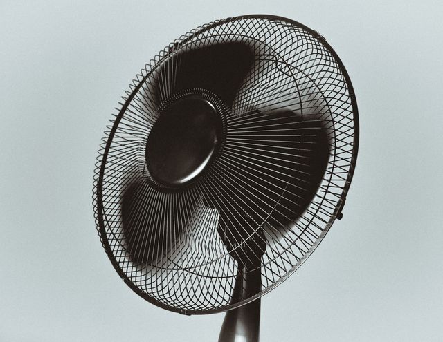 Close-up of vintage black electric fan with spinning blades, showcasing classic design and functionality. Ideal for use in articles or advertisements about ventilation, cooling solutions, and home appliances. Can also be used to evoke nostalgic feelings or portray retro technological advancements.