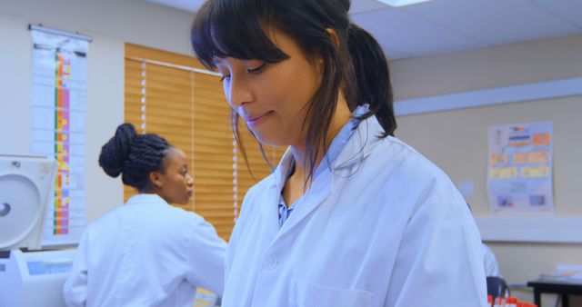 Female scientists are conducting experiments in a modern laboratory, wearing lab coats and using laboratory equipment. The scene emphasizes teamwork, focus, and professionalism in scientific research and healthcare. Suitable for promoting educational materials, scientific research, medical advancements, and empowering women in STEM.