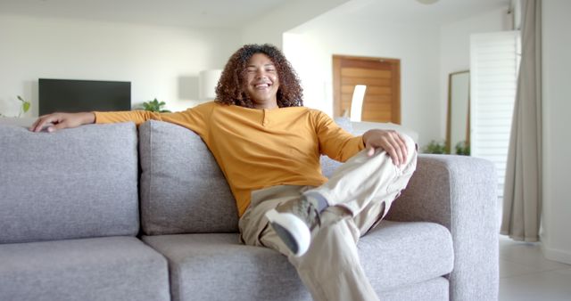 Relaxed Young Man Lounging on Modern Couch in Home - Download Free Stock Images Pikwizard.com