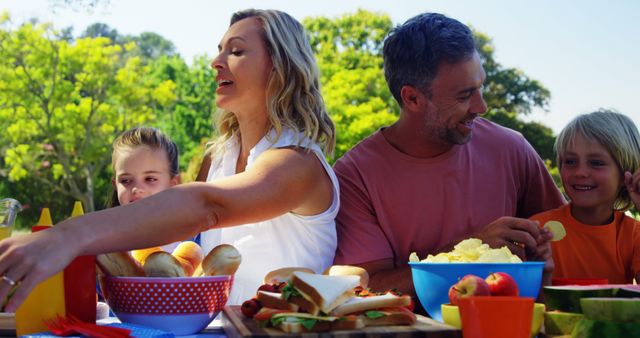 Happy family enjoying outdoor picnic with healthy food - Download Free Stock Images Pikwizard.com