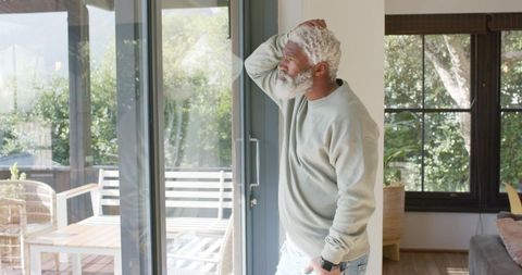 Senior African American Man Standing by Glass Door at Home