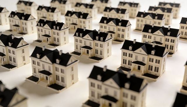 Repeating miniature model houses arranged in precise grid conveying uniformity and scale