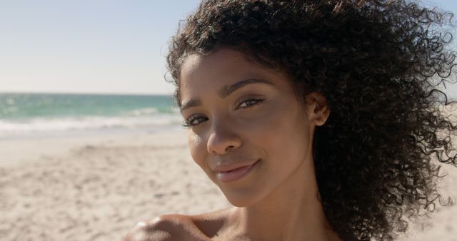 Smiling Woman with Curly Hair Enjoying Sunny Beach Day - Download Free Stock Images Pikwizard.com