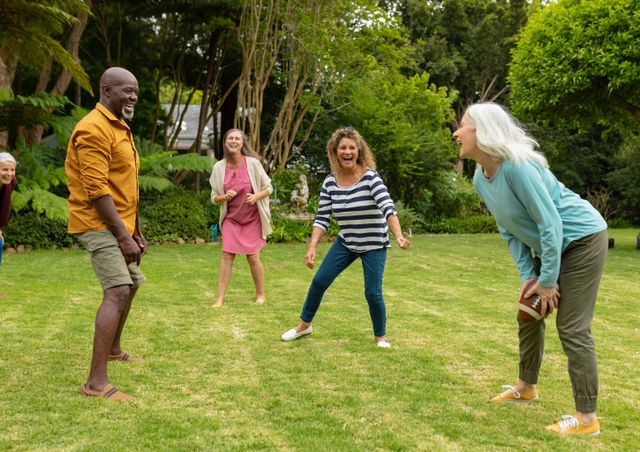 Multiracial active senior male and female friends playing rugby in backyard on weekend. unaltered, lifestyle, friendship, leisure, sport and active seniors.