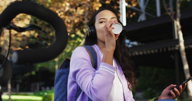 Young Woman Drinking Coffee While Listening to Music Outdoors - Download Free Stock Images Pikwizard.com