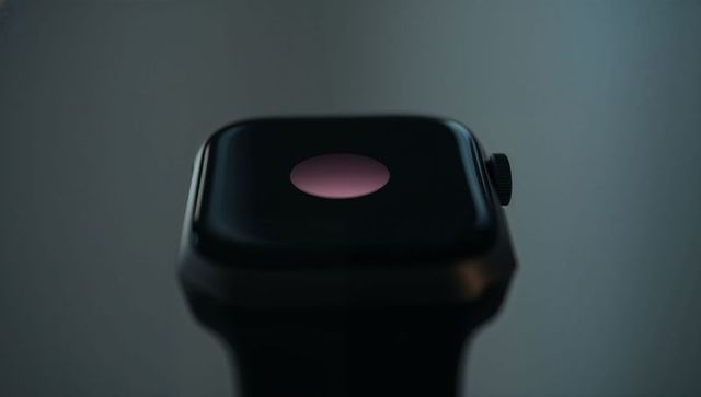 Closeup sleek black smartwatch showing pink notification dot on glossy rectangular display