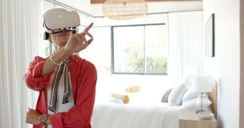 Man Using VR Headset in Modern Bedroom for Futuristic Entertainment