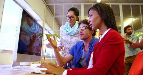 Young Diverse Professionals Collaborating on Project in Modern Office