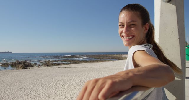 Happy woman enjoying beach view leaning on railing - Download Free Stock Images Pikwizard.com