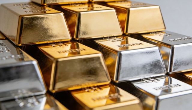 Stacking gold and silver bullion bars reflecting warm and cool metallic tones, macro close-up