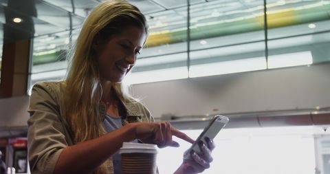Woman Enjoying Coffee and Smartphone at Modern Airport Terminal