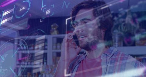 Young man talking on smartphone in retail store with neon holographic interface overlay