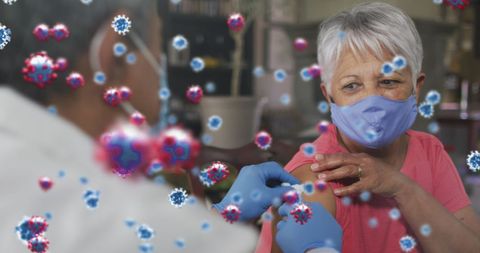 Senior woman receiving covid-19 vaccine amid virus illustrations