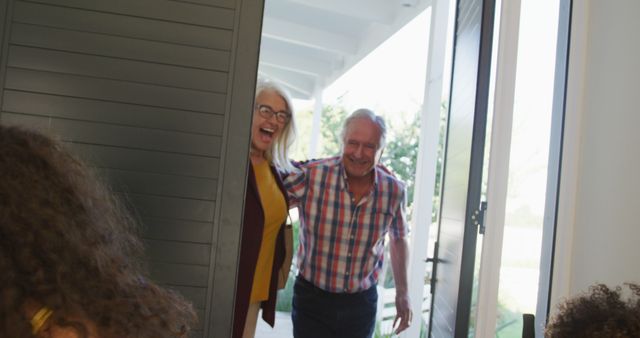 Image of happy caucasian grandparents welcomed at front door by diverse grandson and granddaughter. Family, domestic life and togetherness concept digitally generated image.