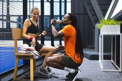 Diverse Training Partners Resting While Hydrating After Exercise