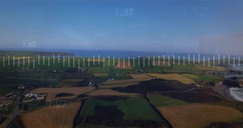 Drone surveying coastal farmland capturing patchwork fields and hedgerows with telemetry hud overlay