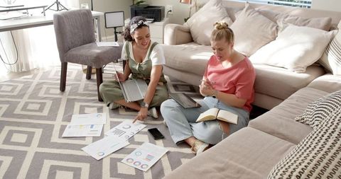 Home-Based Female Colleagues Analyzing Charts for Teamwork