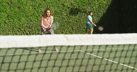 Active Couple Enjoying Tennis Game on Sunny Day
