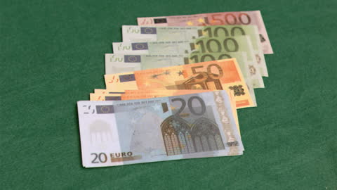 Euro Banknotes Displayed on Green Table Surface