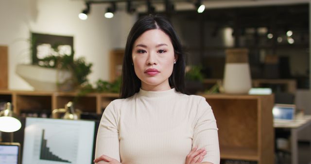 Image of happy asian woman looking at camera in office. Business and working in office at night with technology concept.