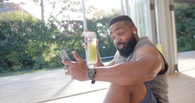 Surprised Man Using Smartphone While Holding Protein Shake - Download Free Stock Images Pikwizard.com