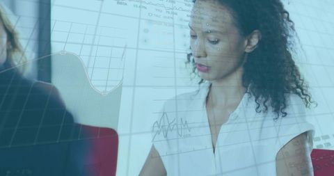 Businesswoman Analyzing Data on Laptop with Projected Charts in Modern Boardroom