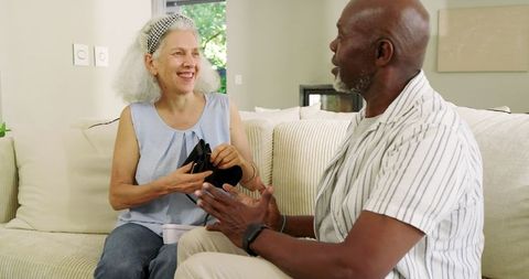 Joyful Senior Couple Sitting Together with Thoughtful Gift Exchange