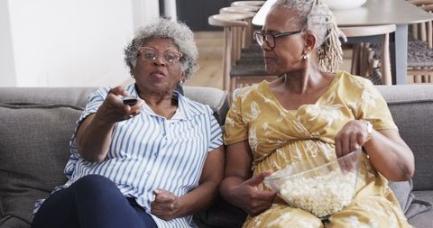 Happy Senior African American Friends Watching TV with Popcorn