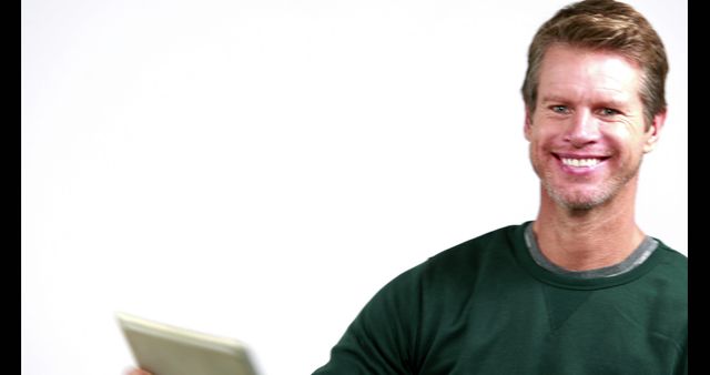 Smiling Man in Green Sweater Holding Tablet - Download Free Stock Images Pikwizard.com