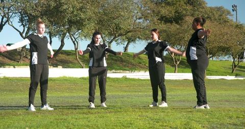 Female Teammates Stretching in Outdoor Athletic Training Session