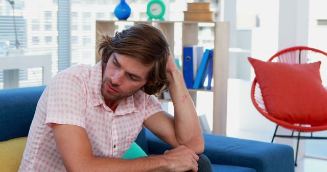 Young Man Sitting on Couch Relaxing in Modern Living Room - Download Free Stock Images Pikwizard.com