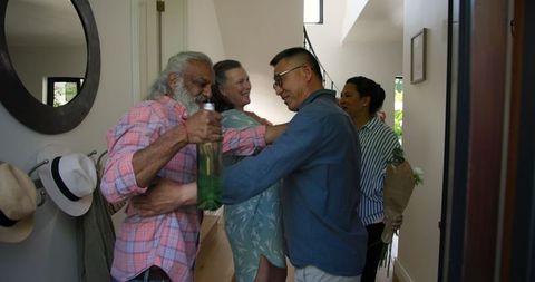 Group of senior friends greeting each other at cozy home gathering