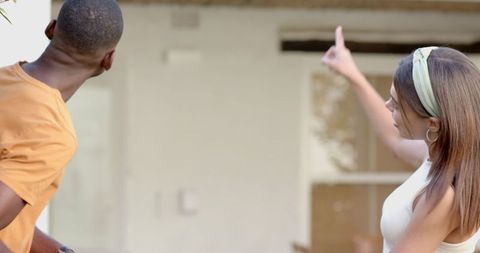 Couple inspecting home exterior for maintenance and renovations