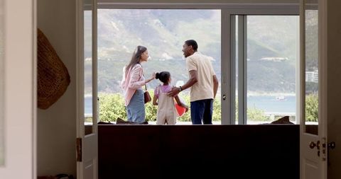 Diverse Family Enjoying Scenic Lake View Through Glass Door