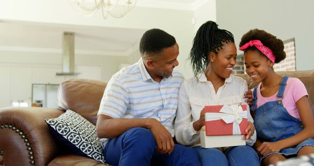 Family Celebrating with Daughter Receiving Gift on Couch - Download Free Stock Images Pikwizard.com