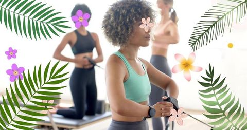 Women doing reformer pilates workout pulling resistance bands in bright studio