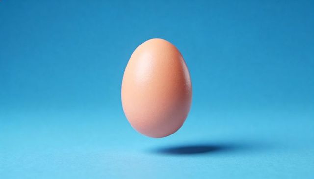 Floating brown egg over blue background with soft shadow minimalist studio composition