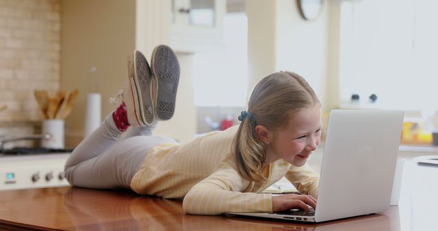 Joyful Child Relaxing While Using Laptop on Table - Download Free Stock Images Pikwizard.com