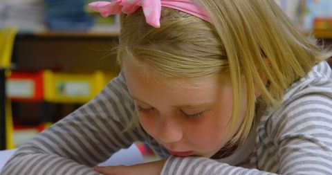 Young Schoolgirl Sleeping on Classroom Desk Relaxed and Peaceful