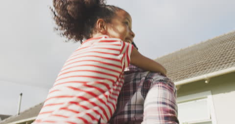 Father and Daughter Piggyback Delight in Garden