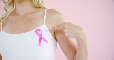 Woman Highlighting Breast Cancer Awareness with Pink Ribbon