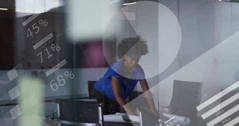 Businesswoman reviewing plans with digital data graphics overlay