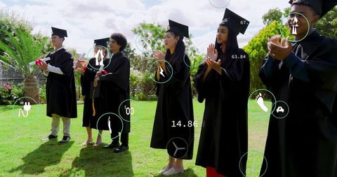 Graduates applauding with ar overlays on campus lawn wearing mortarboards holding diplomas