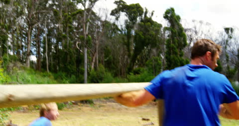 Determined Athletes Navigating Obstacle Course in Forest Area