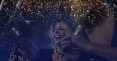 Friends Celebrating Nightlife with Smartphone in Vibrant Club