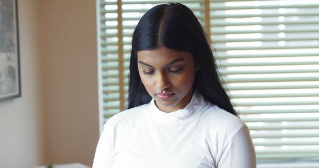 Thoughtful Young Woman Looking Down Indoors - Download Free Stock Images Pikwizard.com