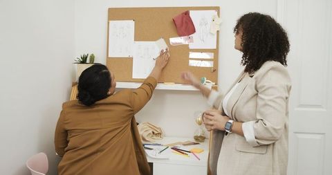 African american designers collaborating on fashion mood board with fabric swatches