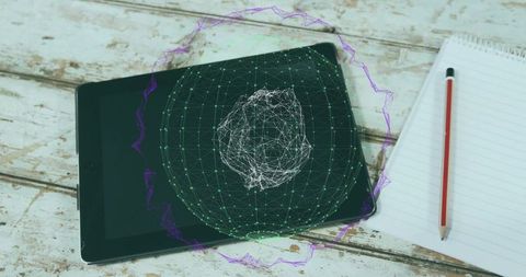 Tablet showing holographic wireframe sphere on rustic wooden desk with notebook and pencil
